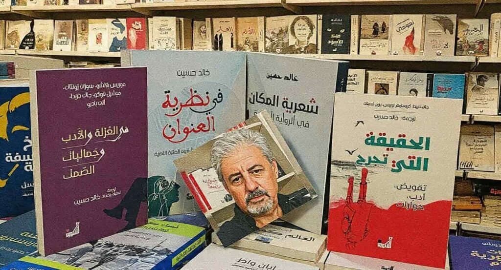 "A display of Arabic literary criticism and translation books by Dr. Khaled Hussein on library shelves, featuring titles like 'The Poetics of Place' and 'In Title Theory', with a prominent portrait of the author and translator Dr. Khaled Hussein in the center."