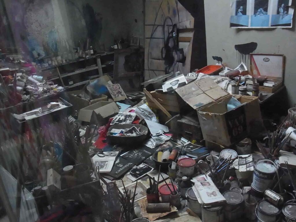 فرانسيس بيكون… الرسَّام الذي أعاد اختراع الجسد في الفن الحديث Reconstructed studio of Francis Bacon at Hugh Lane Gallery in Dublin, showing the artist's chaotic workspace filled with brushes, paint cans, sketches, and materials that reflect his creative process.