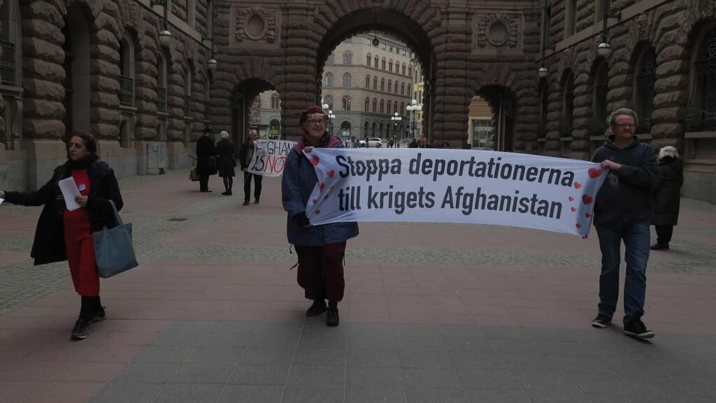 Demonstrators gathered outside the Swedish Parliament in Stockholm during a public protest related to asylum and migration policies.
