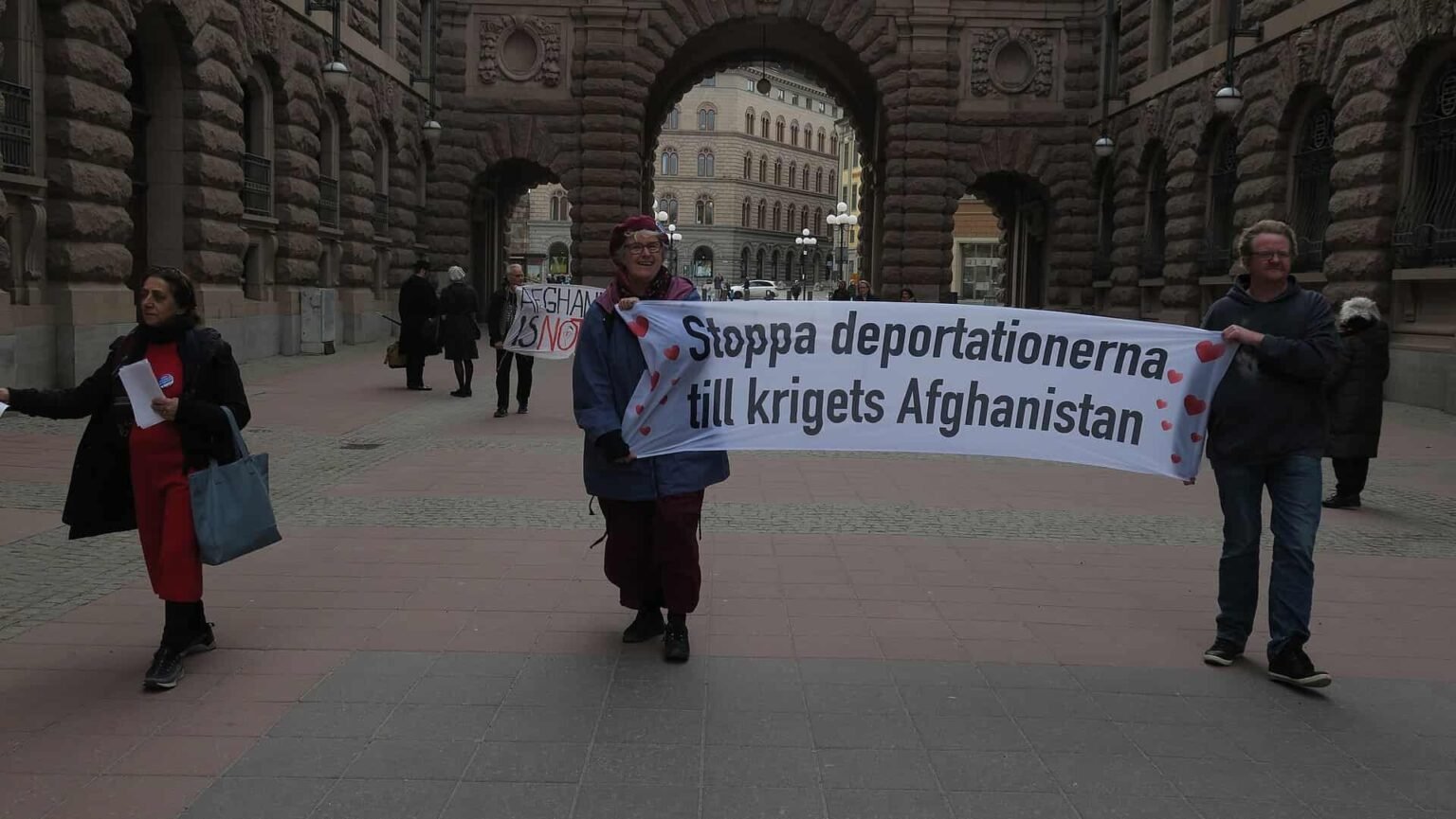 Demonstrators gathered outside the Swedish Parliament in Stockholm during a public protest related to asylum and migration policies.