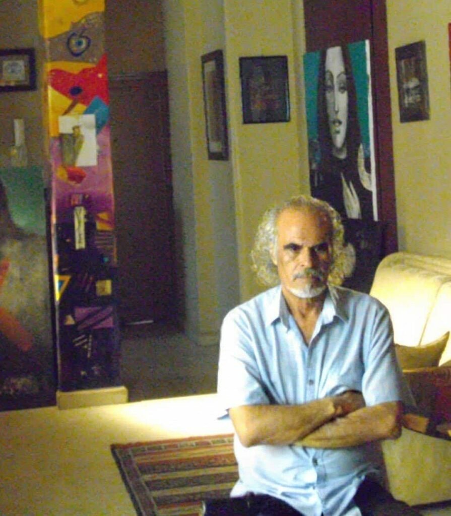 Palestinian artist Mohammad Al-Wahibi seated in his home surrounded by his paintings and artworks
