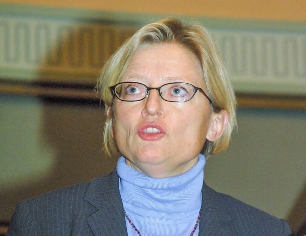 Close-up photograph of former Swedish Foreign Minister Anna Lindh wearing glasses and a blue turtleneck sweater.